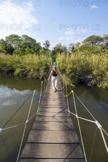 Toruist on the Kavango River, suspension bridge at Camp Kwando, Zambezi region, Caprivi Strip,