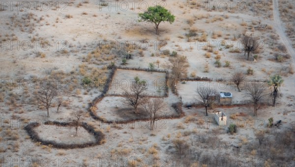 Settlement, simple house and fence, dry savanna landscape, near Maun, aerial view, Okavango Delta,