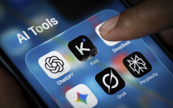 In this photo illustration, a person uses the Kimi AI chatbot on a smartphone while the KIMI logo