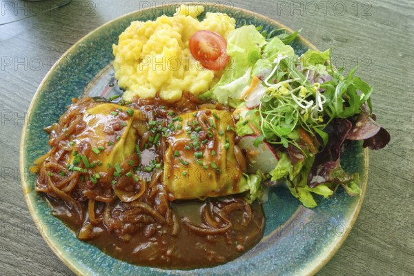 Swabian cuisine, ravioli with potato salad, gravy with onions, colorful salad, mixed salad side