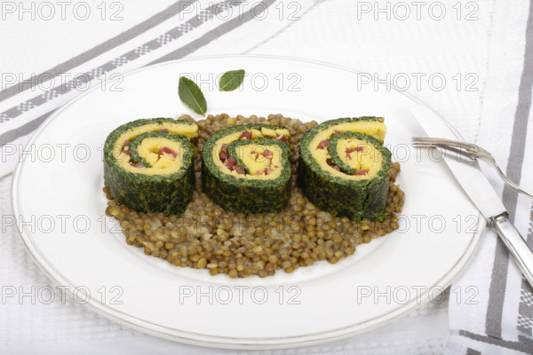 Southern German cuisine, polenta spinach roulade with alblentils served on serving platter, bay