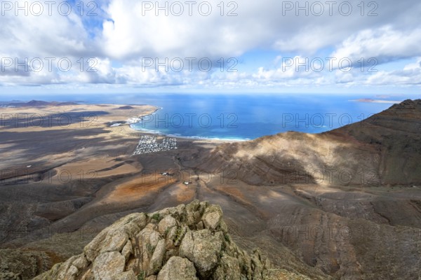 View from the Risco de Famara cliffs to the coast and the sea with the Famara beach, Playa de