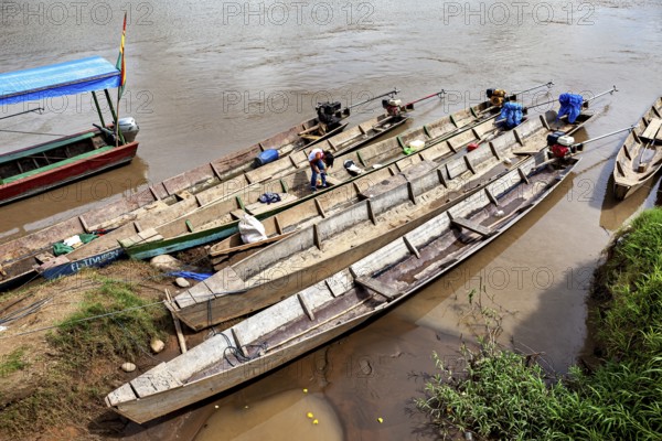 Person on wooden longboats on the banks of a quiet river, longboat on a river near Rurrenabaque in