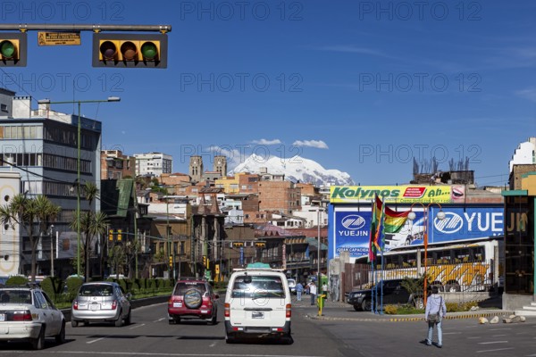 Urban street with traffic and billboards, mountains can be seen in the background, The city of La