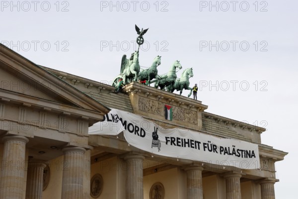 Several activists drop a banner with the inscription Never again genocide, freedom for Palestine