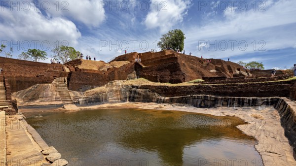An ancient water reservoir amidst archaeological ruins under a vivid sky, The Temples, Dagobas, and