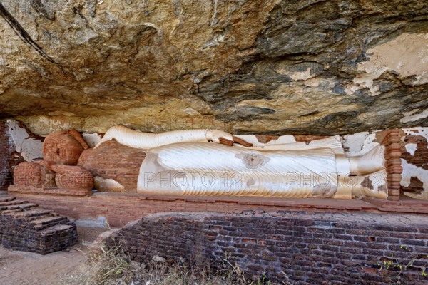 Reclining Buddha embedded in a rock wall, made of sandstone, peaceful and meditative atmosphere,