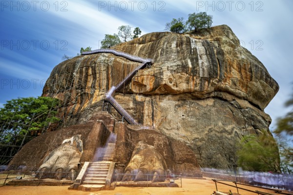 An impressive staircase on a large rock under clouds of rays, The Lion Rock near Sigiriya in Sri