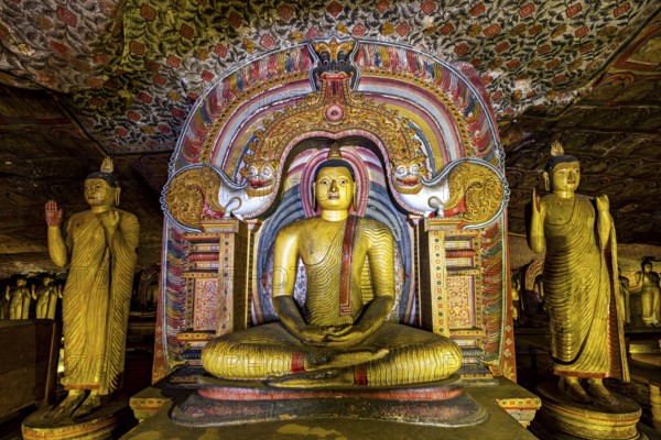 Central Buddha in a richly decorated frame within a cave decorated with ornaments, The cave temples