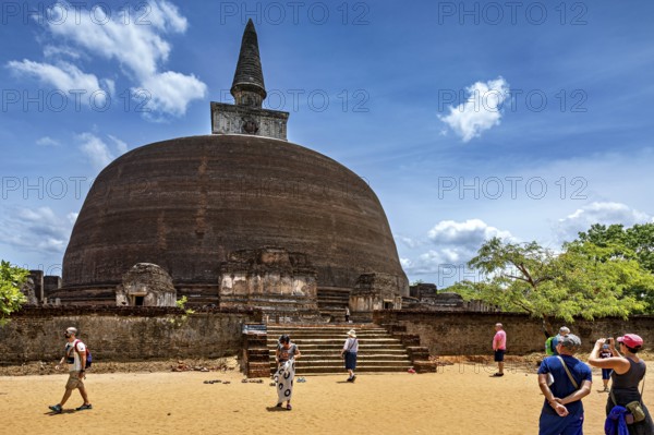 Large ancient stupa with people in the foreground on a sunny day, The temples of Polonnaruwa in Sri