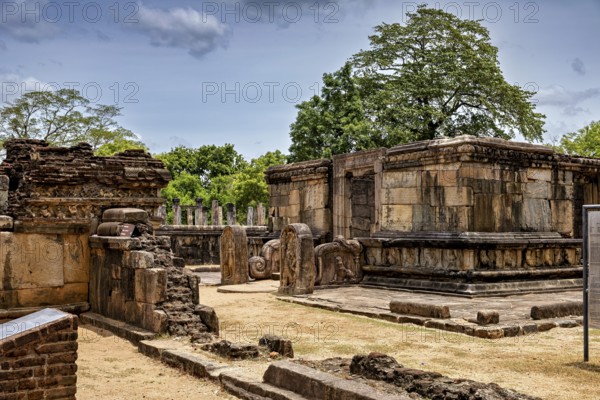 Old stone buildings in a ruined site with trees and blue sky in the background, The temples of