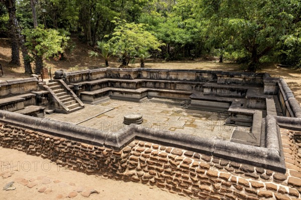 Water basin framed by stones in a wooded setting when the sun is shining, The temples of