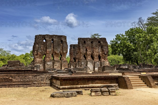Tall brick ruins with multiple openings under a cloudy sky surrounded by trees, The temples of