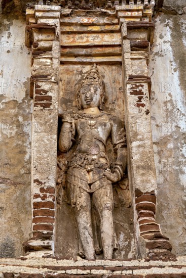 Stone figure in antique style in a decorative niche on a weathered background, The temples of