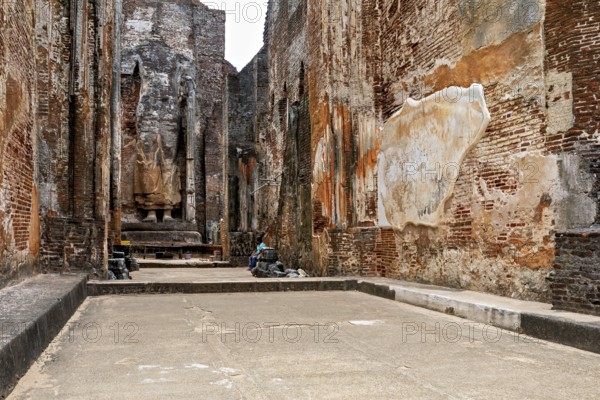 Interior view of an archaeological site with large statues and brick walls, The temples of