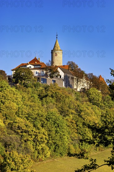A castle with a tower, highlighted by colorful autumn trees and clear skies, The Leuchtenburg near