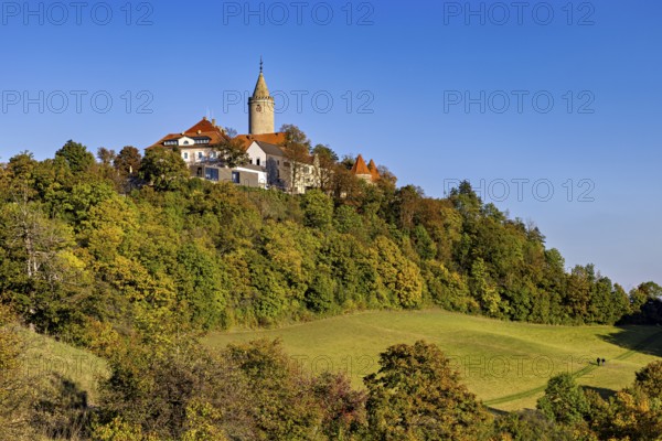 A castle in a hilly wooded area, surrounded by autumn landscape and blue skies, The Leuchtenburg