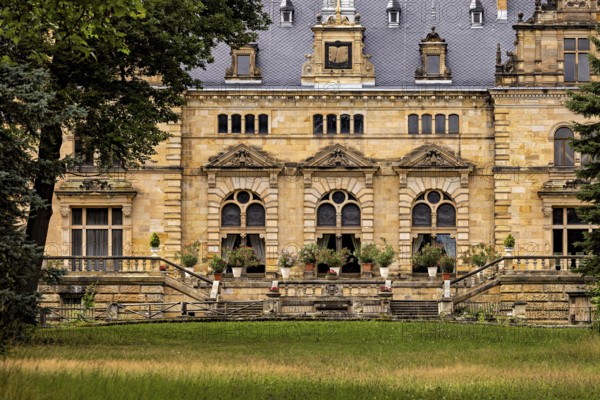 Historic castle façade with decorative windows and a lawn in front of it, The Hummelshain hunting