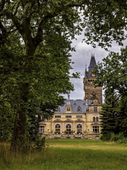 A castle with a high tower, nestled in thick trees, under cloudy skies, The Hummelshain hunting