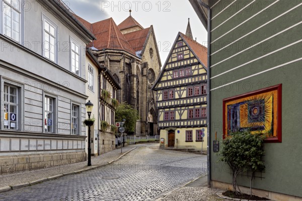 Atmospheric alley with half-timbered houses, church in the background and evening lighting, the old