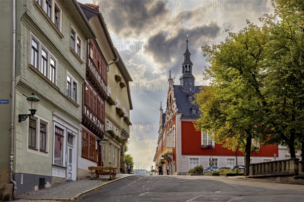 Street with historic facades and church tower under a dramatic sky in the old town, The old town of