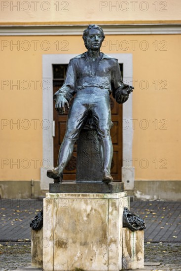 Bronze statue of a man in front of a façade in autumn, Johann Sebastian Bach monument in the old