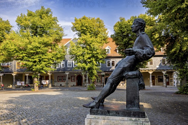 Bronze statue of a man on a paved square with trees, Johann Sebastian Bach monument in the old town