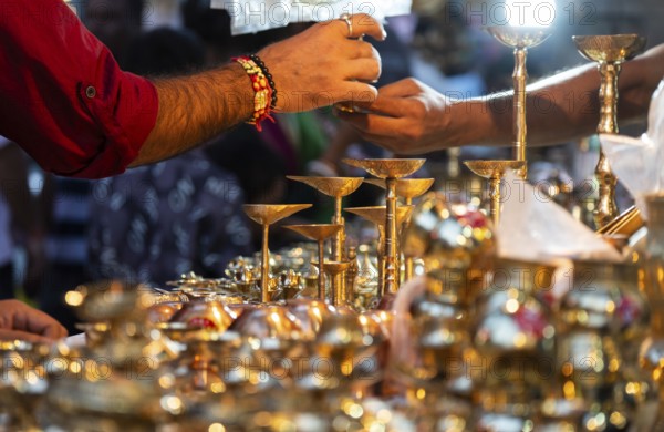 People shop for bronze and other metal items at a roadside stall on Dhanteras, in Guwahati, Assam,