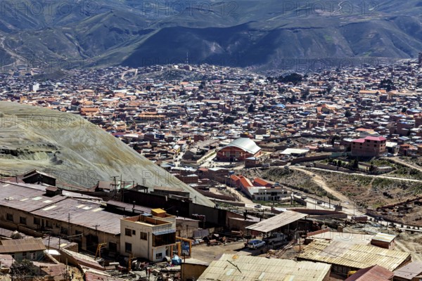 View of a densely populated city in a mountainous landscape with many houses and hills in the