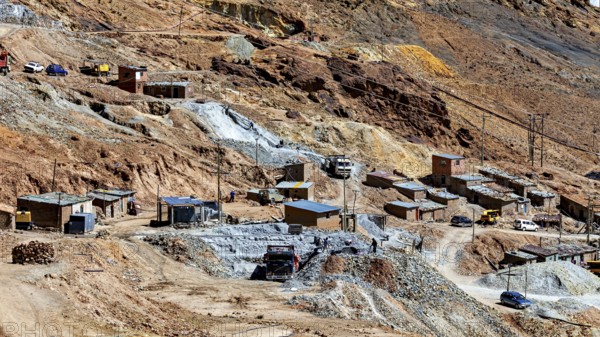 Spacious settlement with huts and vehicles in a barren, stony terrain, The silver mines of Potosi