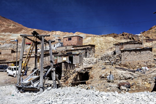 Weathered stone houses and huts on a mountainside with a clear sky, The silver mines of Potosi