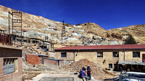 Working area of a mine with people and vehicles in a barren area, The silver mines of Potosi