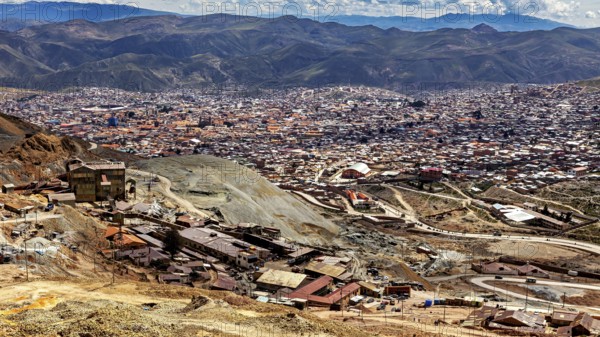 Panoramic view of a wide urban landscape surrounded by majestic mountains and clouds, The silver