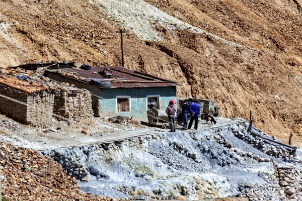 Miners in front of a house with wheelbarrows in a rocky landscape with railings, The silver mines