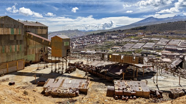 Industrial building in the foreground with sweeping views over a valley and mountains, The silver