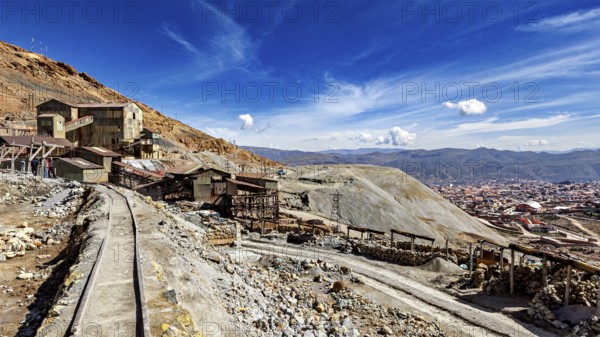 View of abandoned mine buildings and railway tracks in a hilly landscape, The silver mines of