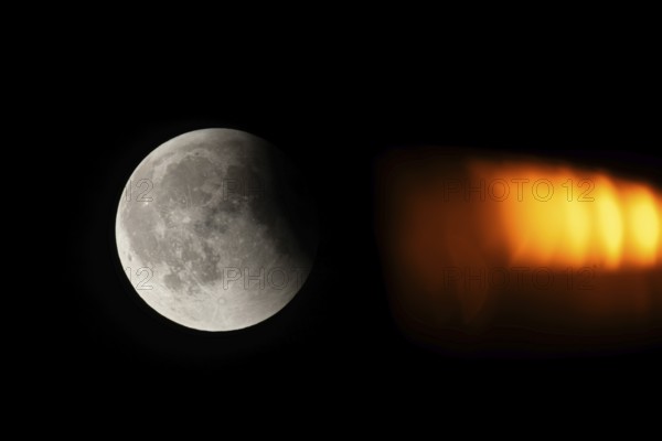 After a total lunar eclipse, the moon appears shortly after its rise in the evening sky as a