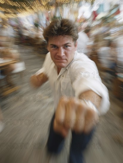 A man gets into a fighting stance, surrounded by dynamic movement and a background filled with