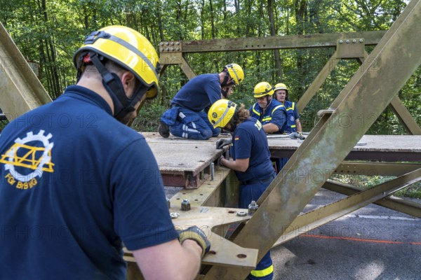 Construction of a temporary bridge over a slipped road crossing a stream, by the bridge