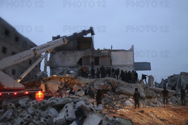 Civil defense teams attempt to rescue civilians trapped under the rubble after a powerful