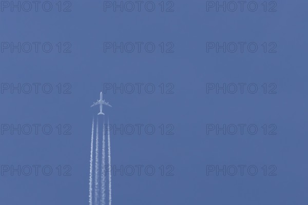 Airbus A340-300 jet aircraft of Lufthansa airlines in flight in a blue sky with vapour trails or