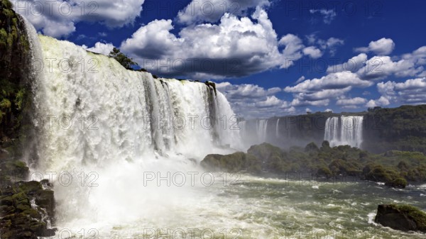 Towering waterfalls flow powerfully under dramatic skies, The Iguazu Falls between Argentina and