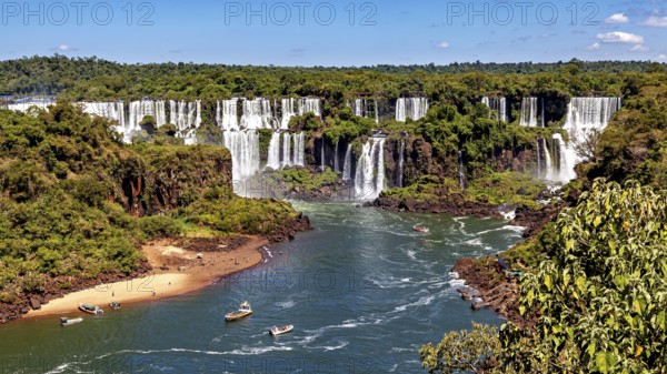 River course to the waterfalls, lined with forest and small boats, The waterfalls of Iguazu between