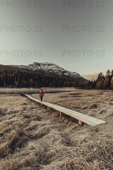 Young woman at Lake Staz near Sankt Moritz in the Engadine in Switzerland. Morning atmosphere with