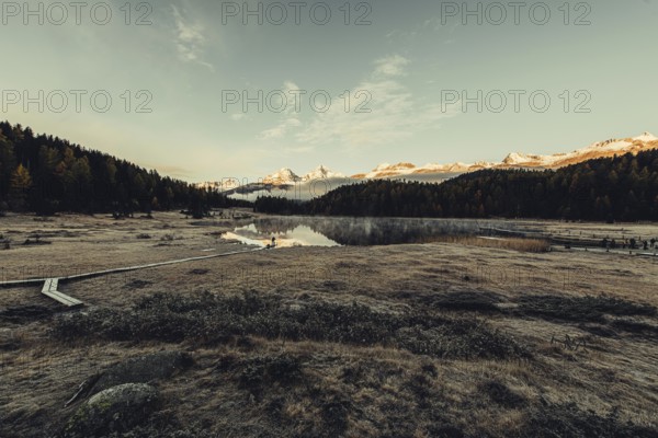 Lake Staz near Sankt Moritz in the Engadin in Switzerland. Morning atmosphere with fog in autumn.
