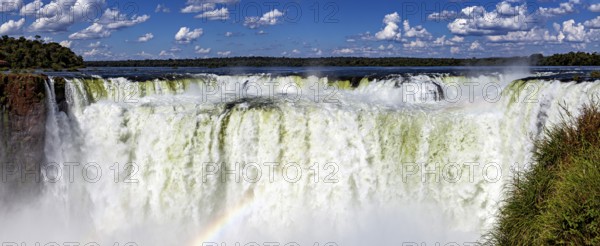 Impressive panoramic view of a chain of waterfalls under a cloudy sky, The Iguazu Falls between