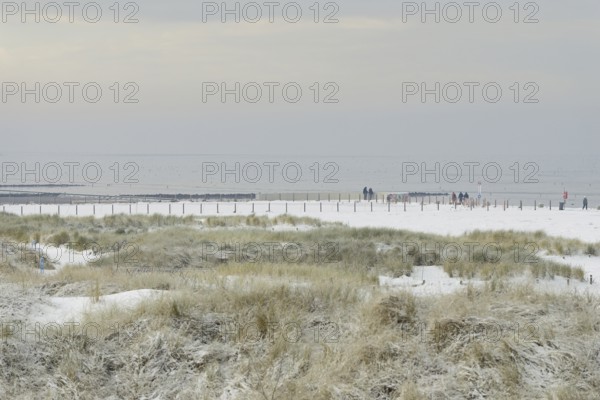 View over the snow-covered dune landscape of Norddeich, Wadden Sea at low tide, North Sea, Lower