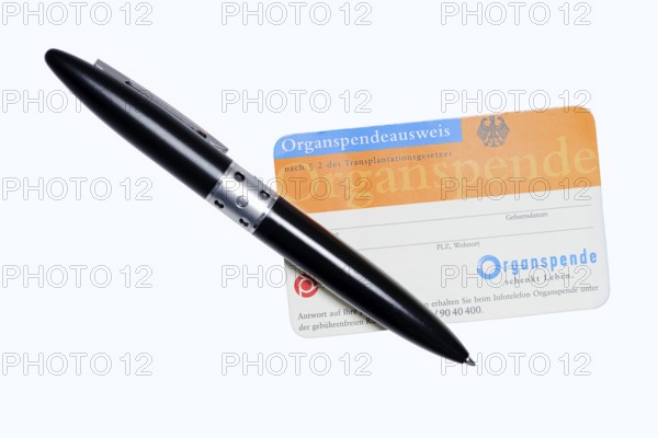 Organ donor card with biros on white background, symbolic image of organ donation