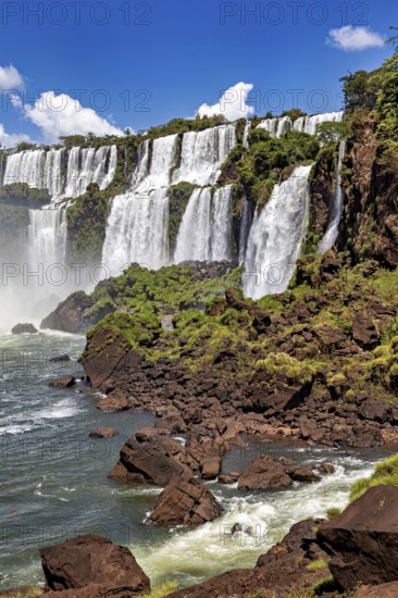 Close-up of waterfalls cascading over rocks in dense green growth, The Iguazu Falls between
