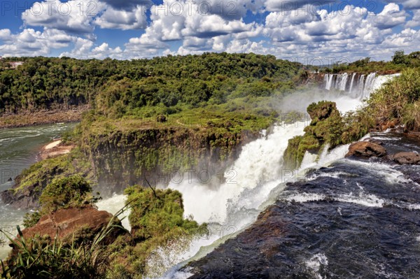 Impressive waterfall with foaming river and lush vegetation, The Iguazu Falls between Argentina and